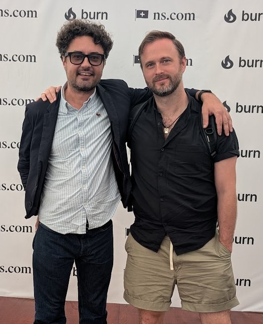 Alexander Rivan Ronalds and Nils Pihl standing arm in arm at an industry event